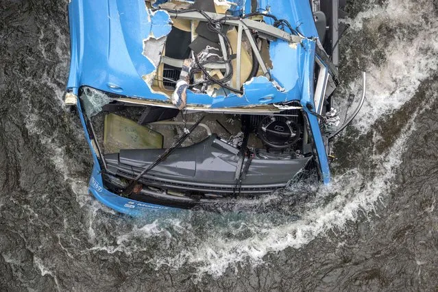 The wreck of a bus lies in the Lerez river after it plunged while crossing a bridge, killing four people, in Cerdedo-Cotobade, northwestern Spain, on December 25, 2022. The accident occurred on December 24 night near Vigo and the border with Portugal. The regional La Voz de Galicia newspaper said the bus was carrying people visiting their loved ones jailed in Monterroso in central Galicia. Rescue operations had to be suspended overnight due to bad weather but resumed in the morning. (Photo by Brais Lorenzo/AFP Photo)