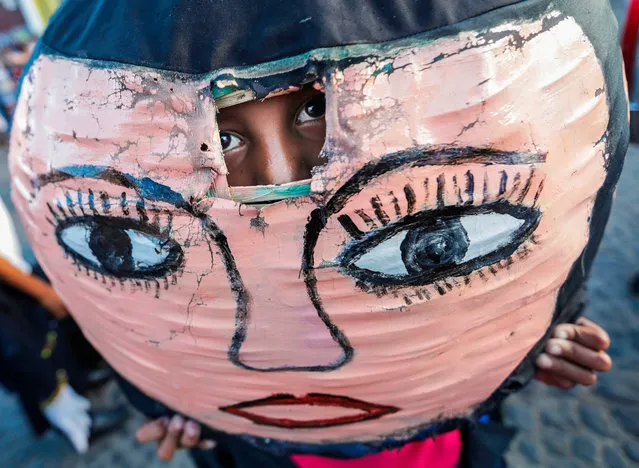 A boy looks through the hole of a mask of the “Enano Cabezon” figure during the traditional dance parade during the XIV Poetry Festival in Granada, 45 km from Managua, Nicaragua, on February 14, 2018. This year, the festival is dedicated to poets Fernando Silva from Nicaragua and Roberto Soza from Honduras. (Photo by Inti Ocon/AFP Photo)