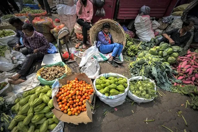 A vegetable seller takes rest at a wholesale vegetable market in Guwahati, India, Wednesday, February 1, 2023. Indian Prime Minister Narendra Modi's government ramped up capital spending by a substantial 33% to $122 billion in an annual budget presented to Parliament on Wednesday, seeking to spur economic growth and create jobs ahead of a general election next year. (Photo by Anupam Nath/AP Photo)