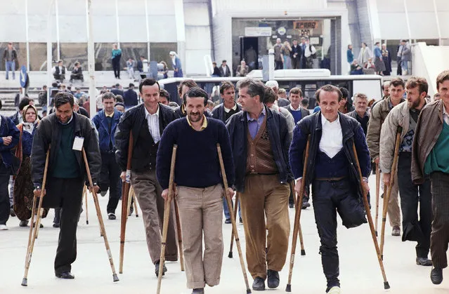 In this April 20, 1993 file photo refugees of Srebrenica, evacuated a day before by U.N. helicopter, walk with their crutches to a nearby hospital in Tuzla. Four-hundred-sixty-nine refugees have been evacuated in a two-day airlift by U.N. forces. (Photo by Karsten Thielker/AP Photo/File)
