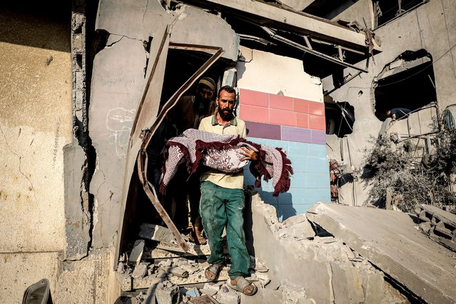 Body of a Palestinian girl, who lost her life, is taken out from the house of al-Shair family in the Tel al-Hawa neighborhood, which was heavily damaged after an Israeli airstrike in Gaza City, Gaza on July 23, 2025. It was reported that 8 civilians, including children, were killed and many others were injured (Photo by Khames Alrefi/Anadolu via Getty Images)