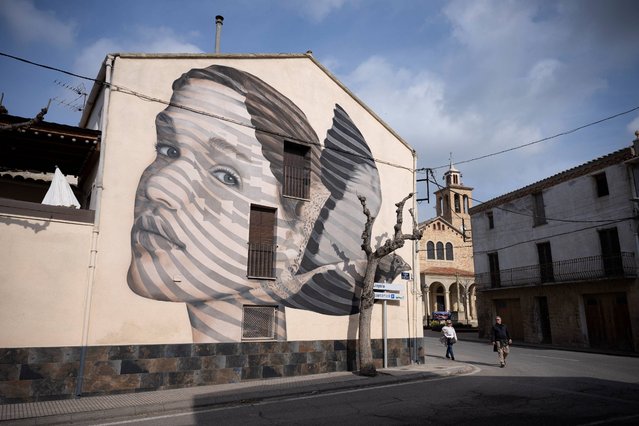 A picture taken on February 15, 2025 shows a mural painted on a building in the village of Penelles, 40 km of Lleida (Lerida), in Catalunya. More than 100 graffitis and murals displayed on Penelles' buildings attract tourism in this depopulated and agricultural  area. The “Gargar project” started in 2016 with a festival gathering streetart artists from Spain and abroad. (Photo by Josep Lago/AFP Photo)