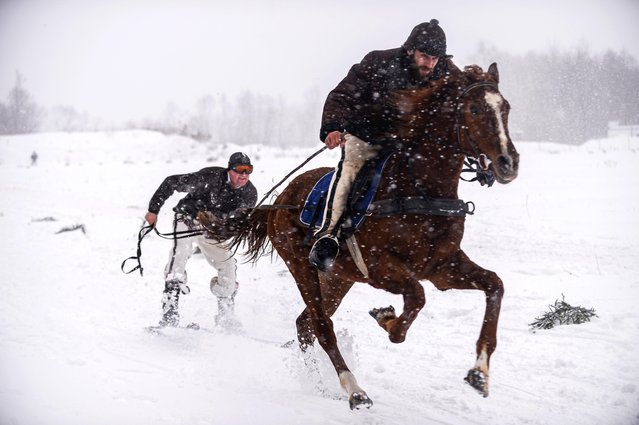 Highlanders from Soutern Poland take part in the UNESCO listed horse carriage competition (Kumoterki) in Bialy Dunajec, Poland on January 30, 2022. In 2017 Kumoterek Races were entered on the UNESCO National Intangible Cultural Heritage List. The origins of the tradition can be traced back to the nineteenth century, when for a long winter period highlander horse-drawn sleds were an irreplaceable means of transport. (Photo by Omar Marques/Anadolu Agency via Getty Images)