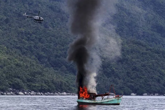 An unmanned Vietnamese fishing boat is blown up and sunk by the Indonesian navy, according to Antara Foto, off the Natuna sea in Anambas, Kepulauan Riau province, December 5, 2014 in this photo taken by Antara Foto. (Photo by Immanuel Antoneus/Reuters/Antara Foto)