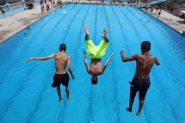 People jump into a swimming pool seeking relief from the summer heat, in Sanaa, Yemen on August 7, 2025. (Photo by Khaled Abdullah/Reuters)