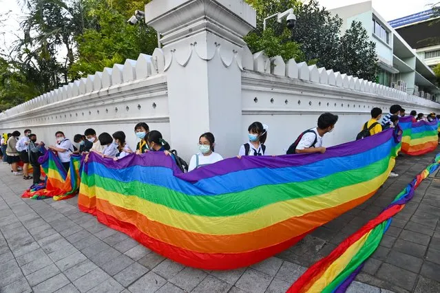 Students hold up a rainbow flag in support of the LGBTQ movement during a “Bad Student” protest outside the Ministry of Education in Bangkok on December 1, 2020. (Photo by Mladen Antonov/AFP Photo)