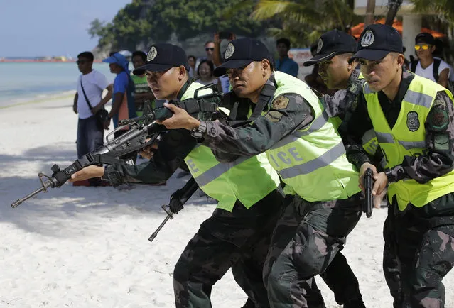 Philippine policemen participate during a security drill at the country's most famous beach resort island of Boracay, in central Aklan province, Philippines Wednesday, April 25, 2018, a day before the government implements its temporary closure. (Photo by Aaron Favila/AP Photo)