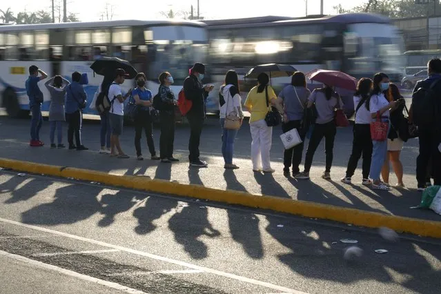 Passengers wait for a ride during morning rush hour as passenger jeepney groups hold a transport strike in Quezon city, Philippines on Monday, March 6, 2023. (Photo by Aaron Favila/AP Photo)