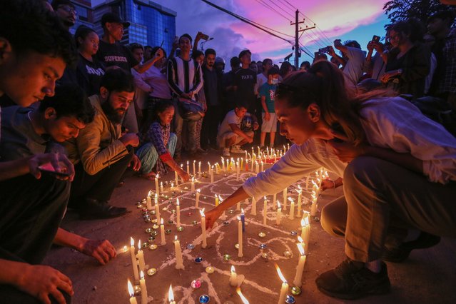 Local people of Nepal light candles to pay tribute to Gen-Z protesters, that were shot dead during Monday's anti-corruption protests, at an altar outside Nepal's burnt parliament on September 13, 2025 in Kathmandu, Nepal. Nepal has been rocked by massive youth-led protests in September 2025, triggered by anger over government corruption, nepotism, and the banning of popular social media platforms. (Photo by Ritesh Shukla/Getty Images)