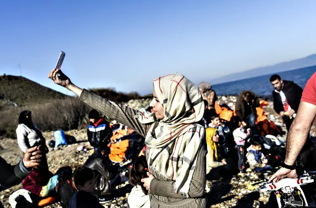 A woman takes a selfie after arriving, along with other migrants and refugees, on the Greek island of Lesbos by crossing the Aegean Sea from Turkey on November 13, 2015. EU leaders on November 12 struck an aid-for-cooperation deal with Africa and proposed a summit this year with Turkey in a two-front push with wary partners to tackle an unprecedented migrant crisis. (Photo by Bulent Kilic/AFP Photo)