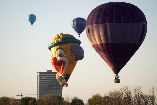 This view shows giant hot air balloons of various shapes being lifted to begin flights from the Metropolitan Park over the city of Leon during the 2025 International Balloon Festival (FIG) in the state of Guanajuato, Mexico on November 15, 2025. (Photo by Mario Armas/AFP Photo)
