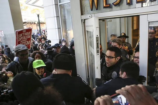 Police scuffle with Black Lives Matter protesters while attempting to close a door to Westlake Mall on Black Friday in Seattle, Washington November 27, 2015. (Photo by David Ryder/Reuters)