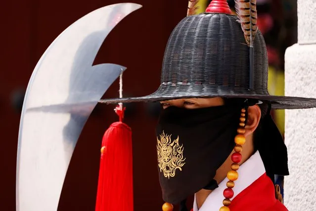 A worker wearing traditional dress wears a mask to prevent the spread of the coronavirus disease (COVID-19) during the daily re-enactment of the changing of the Royal Guards at Gyeongbok Palace in central Seoul, South Korea, July 30, 2020. (Photo by Kim Hong-Ji/Reuters)