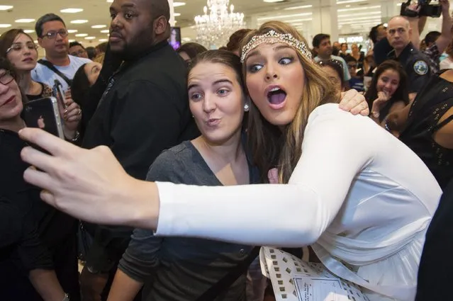Miss Venezuela 2014 Migbelis Castellanos poses for a selfie with a fan during the Chinese Laundry shoes meet-and-greet at Macy's in Miami International Mall in this January 10, 2015 picture provided by the Miss Universe Organization. (Photo by Reuters/Miss Universe Organization)