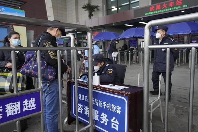 Travelers are screened before entering the Wuchang train station at the start of the annual Lunar New Year travel in Wuhan in central China's Hubei province on Thursday, January 28, 2021. Efforts to dissuade Chinese from traveling for Lunar New Year appeared to be working as Beijing’s main train station was largely quiet and estimates of passenger totals were smaller than in past years. (Photo by Ng Han Guan/AP Photo)