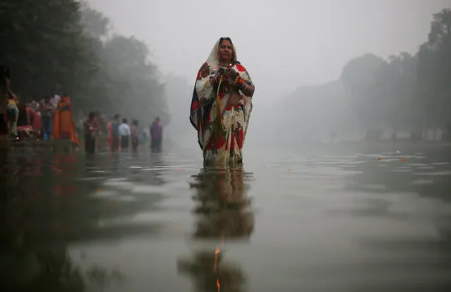 A Hindu devotee worships the Sun god amidst heavy smog at a pond during Chhath Puja in New Delhi, India November 6, 2016. (Photo by Adnan Abidi/Reuters)