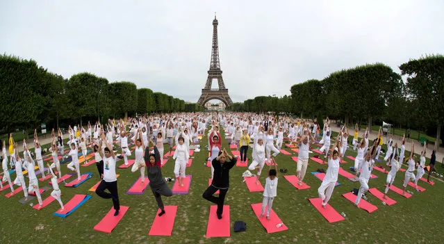 People gather for an open-air yoga session near the Eiffel tower in Paris, France on June 17, 2018. (Photo by Philippe Wojazer/Reuters)