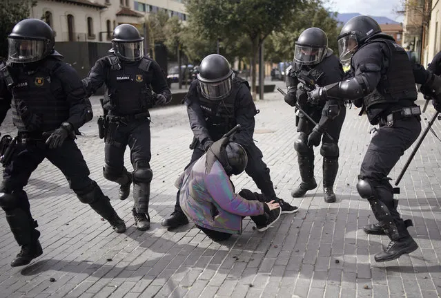 A demonstrator is detained by police officers during a protest against Spain's far-right Vox party supporters, as they were campaigning at Olot city, in Girona province, Spain, Wednesday, February 10, 2021. Catalan regional elections will be held on Sunday. (Photo by Joan Mateu/AP Photo)