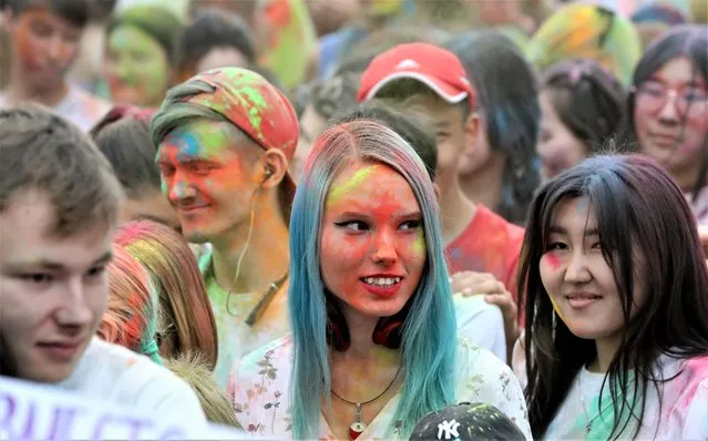 People take part in the Festival of Colors at Asanbai Park in Bishkek, Kyrgyzstan, 27 May 2023. The festival brings together young people sprinkling each other with colored powder to pay homage to India's traditional Holi festival. (Photo by Igor Kovalenko/EPA/EFE)