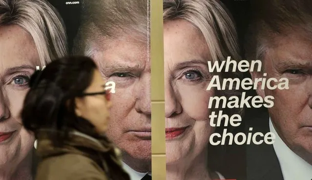 A woman walks by banners of Democratic presidential candidate Hillary Clinton and Republican presidential candidate Donald Trump during an election watch event hosted by the U.S. Embassy in Seoul, South Korea, Wednesday, November 9, 2016. The United States headed for the polls to vote for their new president on Tuesday. (Photo by Lee Jin-man/AP Photo)