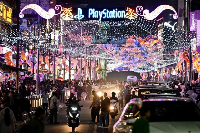 People gather to shop ahead of Christmas, at the illuminated Church Street in Bengaluru on December 21, 2024. (Photo by Idrees Mohammed/AFP Photo)