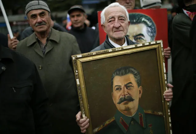 A man carries a portrait of Soviet leader Joseph Stalin while marching during a rally to mark Stalin's birthday anniversary at his hometown in Gori, Georgia, December 21, 2015. (Photo by David Mdzinarishvili/Reuters)
