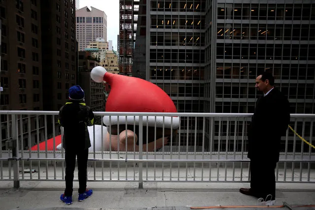 A man and a child observes the Elf on a Shelf float on its way down 6th Avenue during the 90th Macy's Thanksgiving Day Parade in the Manhattan borough of New York, U.S. November 24, 2016. (Photo by Saul Martinez/Reuters)