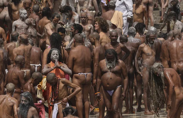 Naked Hindu holy men gather to take holy dips in the Ganges River during Kumbh Mela, or pitcher festival, one of the most sacred pilgrimages in Hinduism, in Haridwar, northern state of Uttarakhand, India, Monday, April 12, 2021. Tens of thousands of Hindu devotees gathered by the Ganges River for special prayers Monday, many of them flouting social distancing practices as the coronavirus spreads in India with record speed. (Photo by Karma Sonam/AP Photo)