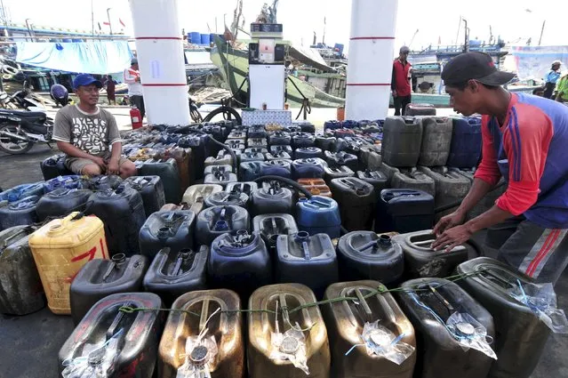 A fisherman sits on a jerry can while queuing to buy diesel fuel for their boat at the Pertamina fuel station in Tegal, Indonesia's Central Java province, January 7, 2016 in this photo taken by Antara Foto. (Photo by Oky Lukmansyah/Reuters/Antara Foto)