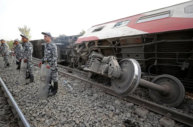 Egyptian police officers stand guard at the site where train carriages derailed in Qalioubia province, north of Cairo, Egypt April 18, 2021. (Photo by Mohamed Abd El Ghany/Reuters)