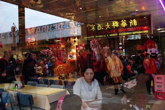 Lion dancers are reflected in the window of a restaurant as they perform in the Chinatown district of Paris, to celebrate the Chinese New Year, in Paris, Thursday, February 19, 2015. (Photo by Thibault Camus/AP Photo)