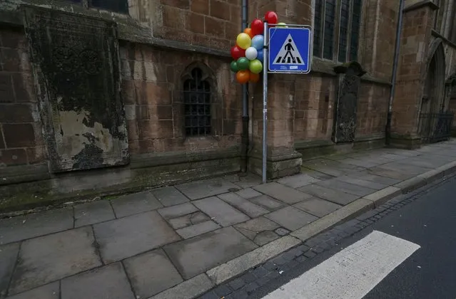 Balloons are attached to a street sign as a decoration for the carnival in the empty street of the northern German town of Braunschweig, February 15, 2015. A carnival parade in Braunschweig planned for Sunday lunchtime has been cancelled at short notice due to a concrete threat of an Islamist attack, police said. (Photo by Ralph Orlowski/Reuters)