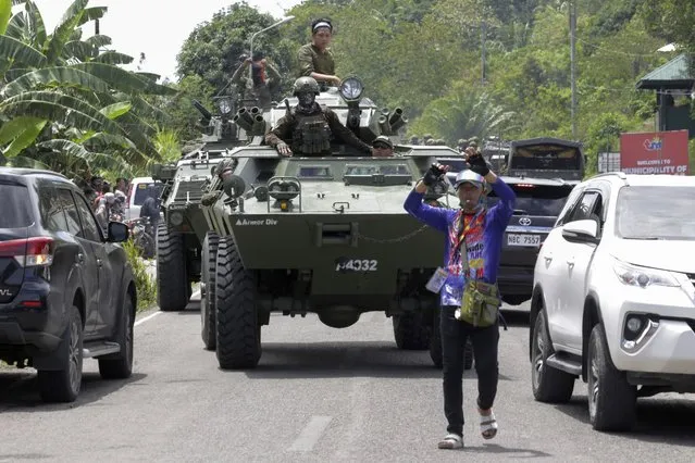 Armored personnel carriers make their way along traffic as they augment security forces in Datu Paglas, Maguindanao province, southern Philippines on Saturday May 8, 2021. Dozens of Muslim militants occupied a public market overnight in the southern Philippines before fleeing after a tense standoff with government forces, officials said Saturday. (Photo by Ferdinandh Cabrera/AP Photo)
