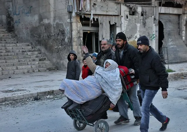 Syrian residents fleeing the violence in the eastern rebel- held parts of Aleppo evacuate from their neighbourhoods through the Bab al- Hadid district after it was seized by the government forces, on December 7, 2016. (Photo by George Ourfalian/AFP Photo)