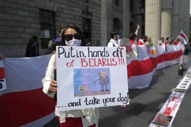 A protesters poses as members of the Belarusian community in Ireland, protest outside the GPO building in Dublin, Ireland, in support of political prisoners in Belarus, Saturday May 29, 2021. (Photo by Niall Carson/PA Wire via AP Photo)