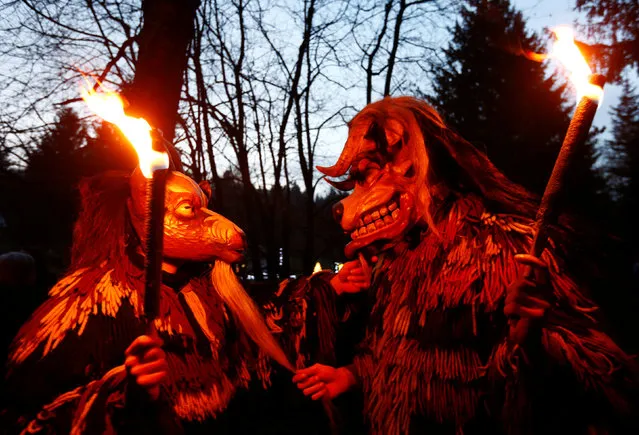 Costumed participants perform during a traditional Perchtenlauf (Perchten parade) in Osterseeon near Munich, Germany, December 17, 2016. (Photo by Michaela Rehle/Reuters)