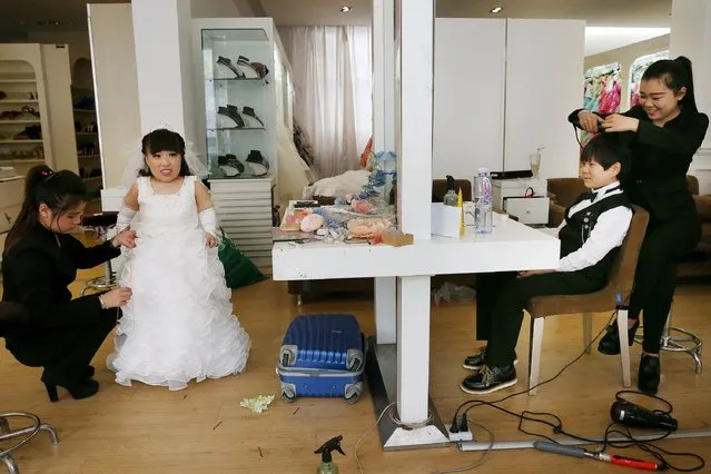 A dwarf couple, Hai Lulu and her fiance, Li Zhouyao prepare for their wedding pictures to be taken, at a studio in Luoyang, Henan province, March 19, 2015. The studio prepared custom-tailored wedding dress and suits for Hai and Li. The couple met each other two years ago online and decided to step into marriage, according to local media. (Photo by Reuters/Stringer)