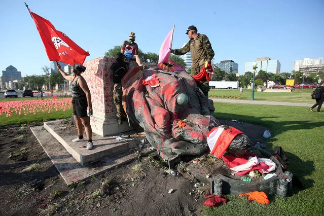 A defaced statue of Queen Victoria lies after being toppled during a rally, following the discovery of the remains of hundreds of children at former indigenous residential schools, outside the provincial legislature on Canada Day in Winnipeg, Manitoba, Canada on July 1, 2021. (Photo by Shannon VanRaes/Reuters)