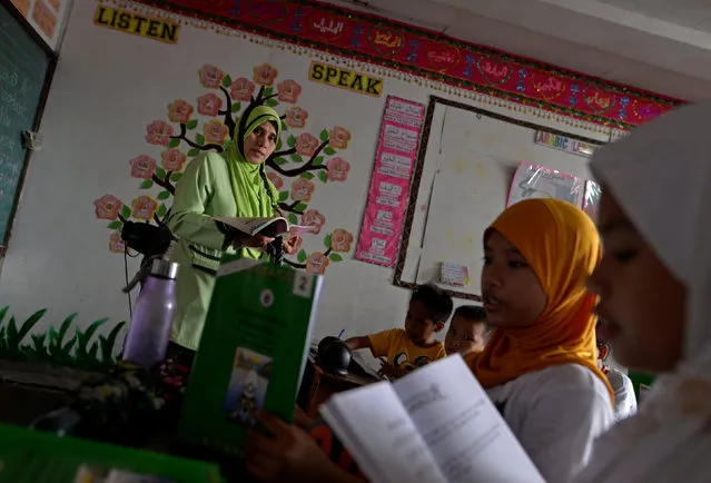 Zainab Omar, 41, teacher, from Taguig city, teaches her pupils Koranic verses at a religious school in Taguig city, Metro Manila, Philippines October 14, 2016. “The children are safer now. Parents used to accompany their children to school before Duterte sat as president. Now they let their children go to school by themselves”, she said. (Photo by Ezra Acayan/Reuters)