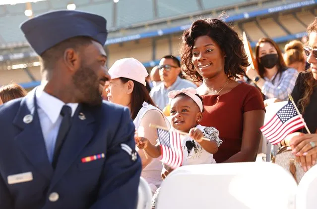 U.S. Air Force Airman Michael Drah (L), originally from Ghana, smiles with his wife Akosua Yeboah-Drah and daughter Rashana Drah before he became a U.S. citizen at a naturalization ceremony at Dodger Stadium on August 29, 2022 in Los Angeles, California. The naturalization ceremony welcomed more than 2,100 immigrants from 120 countries and featured an appearance by Los Angeles Dodgers legend Fernando Valenzuela who grew up in the small town of Navojoa, Mexico. (Photo by Mario Tama/Getty Images)