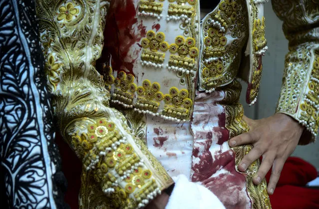 Bloodied Colombian bullfighter Juan de Castilla rests during his performance at the Macarena bullring on February 14, 2016 in Medellin, Antioquia department, Colombia. De Castilla began bullfighting with the support of Colombian artist Fernando Botero, paying tribute to his neighborhood, one of the most violent of the city, with a performance called in Spanish “Encerrona”, where the matador stands alone against all the bulls of the announced lineup. (Photo by Raul Arboleda/AFP Photo)