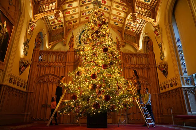 Royal Collection Trust staff add the finishing touches to a Christmas tree in St George's Hall during a photo call for Christmas decorations at Windsor Castle, Berkshire, UK on Thursday, November 30, 2023. (Photo by Lucy North/PA Images via Getty Images)