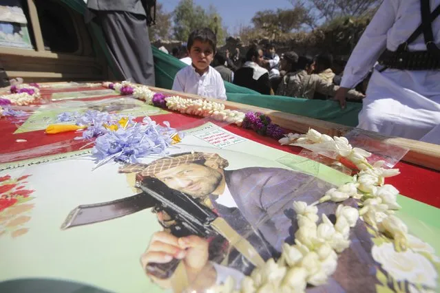 A boy looks while on a vehicle carrying the coffin of Lutf al-Quhum, a prominent pro-Houthi religious singer, during a funeral procession in Sanaa February 18, 2016. Quhum and a Houthi fighter were reportedly killed during fighting against pro-government forces in the country's central province of Marib. (Photo by Mohamed al-Sayaghi/Reuters)