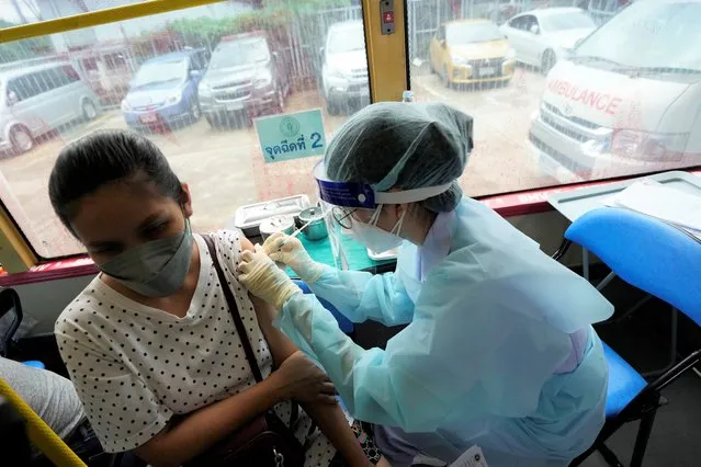 A health worker administers a dose of the AstraZeneca COVID-19 vaccine inside a mobile vaccination unit in Bangkok, Thailand, Wednesday, September 8, 2021. Bangkok health authorities sent out its first mobile vaccination unit to support its vaccination campaign in the community. The city hopes that the converted bus will help health workers reach those with mobility issues, and people with tight work schedules to get vaccinated. (Photo by Sakchai Lalit/AP Photo)