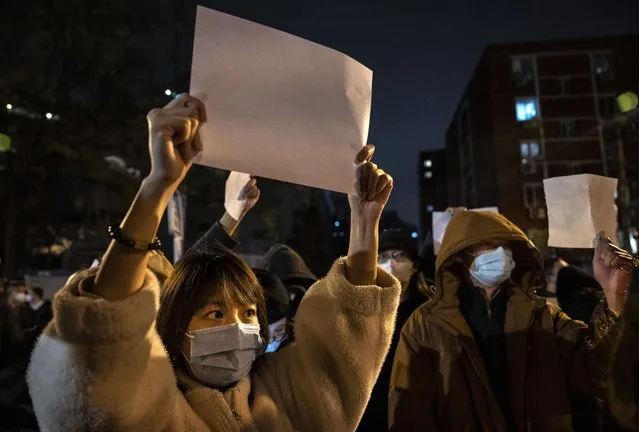 Protesters hold up pieces of paper against censorship and China's strict zero COVID measures on November 27, 2022 in Beijing, China. Protesters took to the streets in multiple Chinese cities after a deadly apartment fire in Xinjiang province sparked a national outcry as many blamed COVID restrictions for the deaths. (Photo by Kevin Frayer/Getty Images)
