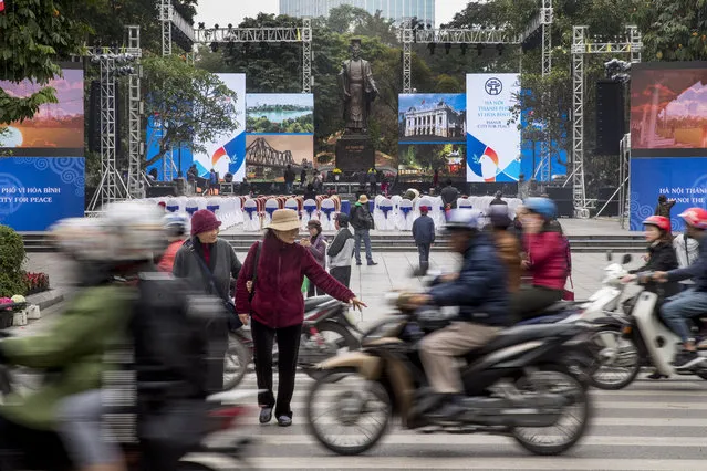 Motorbikes speed past the Emperor Ly Thai To Statue in Hanoi, Vietnam, Tuesday, February 26, 2019, where an event space is being set up for the second summit between U.S President Donald Trump and North Korean leader Kim Jong Un. (Photo by Andrew Harnik/AP Photo)