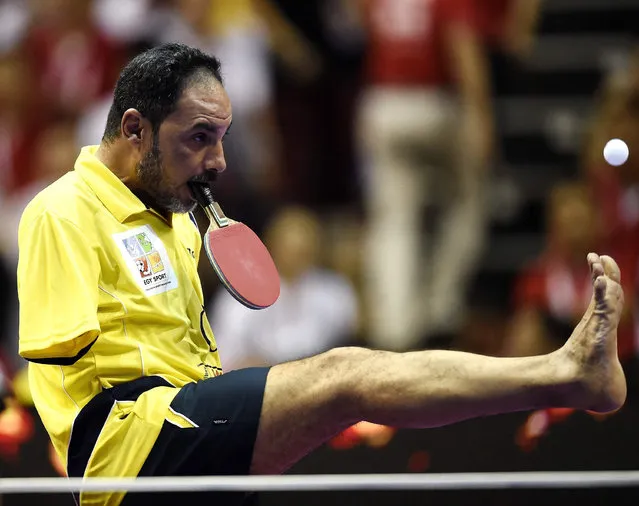 Table Tennis player Ibrahim Hamato of Egypt serves with his foot during an exhibition match at the 2016 World Team Table Tennis Championships at Malawati Stadium in Shah Alam on March 6, 2016. (Photo by Manan Vatsyayana/AFP Photo)