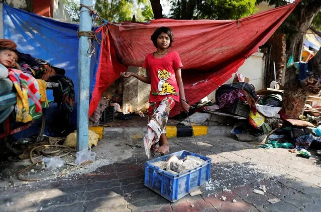 A mentally disabled girl named America Patni, 18, is tied to a plastic crate full of stones at her makeshift shelter on a roadside in Ahmedabad, India, January 23, 2017. (Photo by Amit Dave/Reuters)