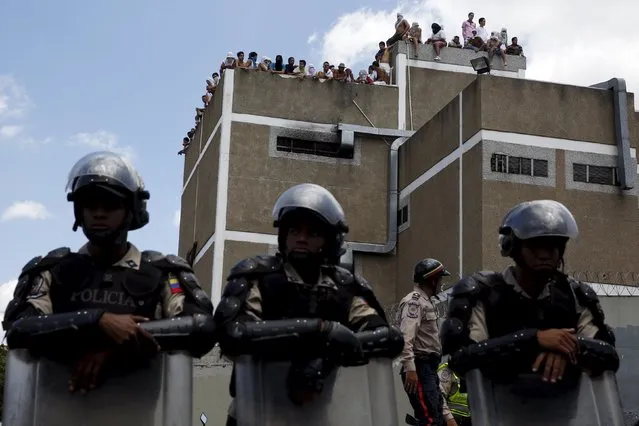 Inmates gather on the roof of the prison of the National Bolivarian Police during a riot in Caracas, Venezuela April 27, 2015. The inmates are protesting against overcrowding in the prison and have taken a policeman as hostage, according to local media. (Photo by Carlos Garcia Rawlins/Reuters)