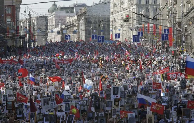 People hold pictures of World War Two soldiers as they take part in the Immortal Regiment march during the Victory Day celebrations in central Moscow, Russia, May 9, 2015. (Photo by Tatyana Makeyeva/Reuters)